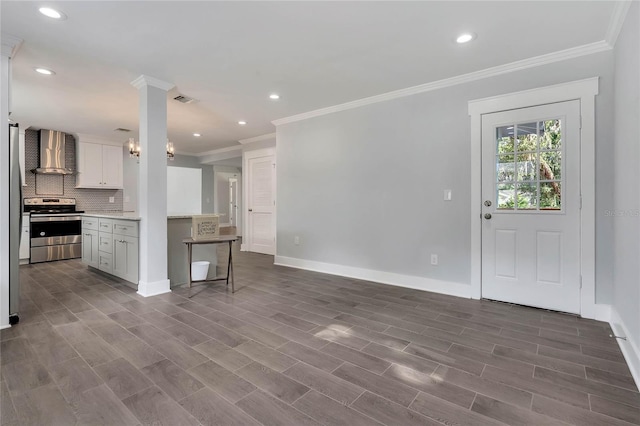 415 S 9th St, Leesburg, FL 34748 - kitchen with light countertops, tasteful backsplash, stainless steel appliances, wall chimney range hood, and baseboards