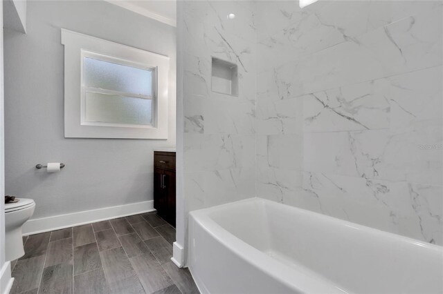 415 S 9th St, Leesburg, FL 34748 - bathroom featuring a washtub, baseboards, toilet, vanity, and wood tiled floor