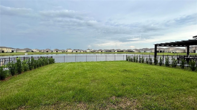 view of yard with a residential view, a water view, and fence