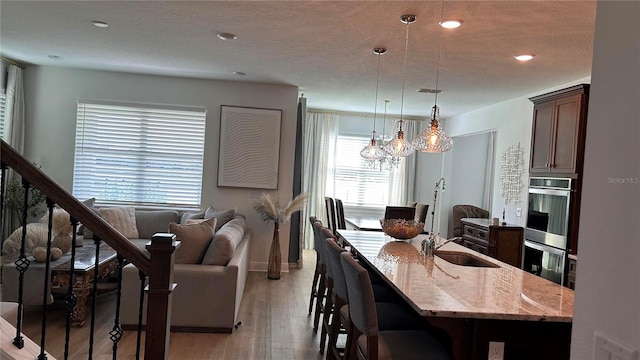 dining space featuring stairs, a textured ceiling, recessed lighting, and light wood-style floors