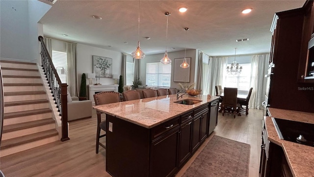 kitchen with light wood-style floors, plenty of natural light, a breakfast bar, and a sink