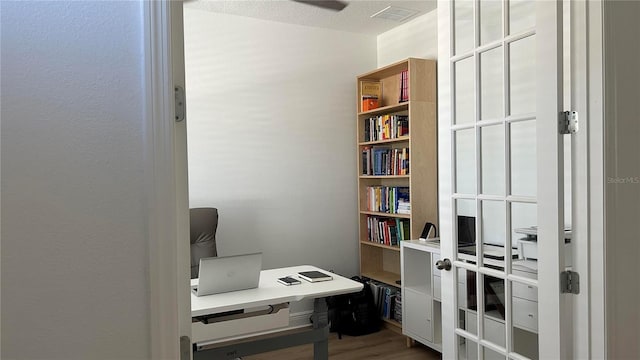 office area featuring light wood finished floors and visible vents