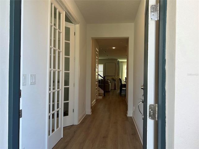 hallway with stairs, baseboards, and wood finished floors