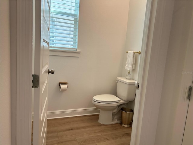 bathroom featuring baseboards, toilet, and wood finished floors