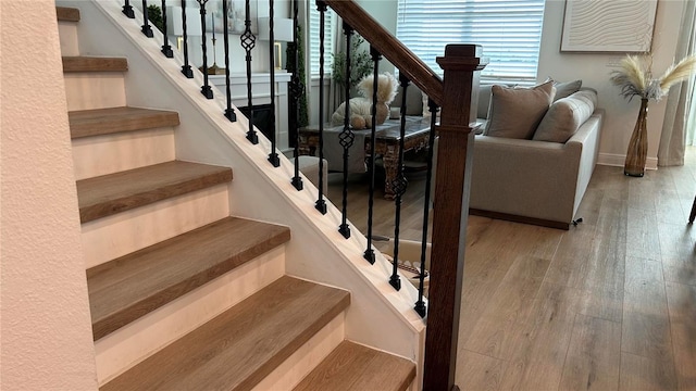 staircase with wood-type flooring and baseboards