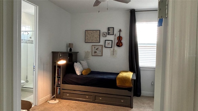 bedroom featuring light carpet, ensuite bath, and multiple windows