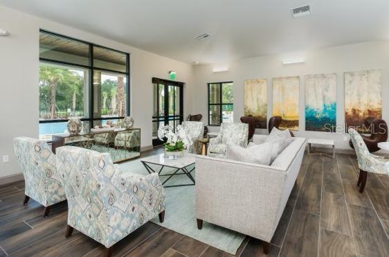 living area with dark wood-style flooring, visible vents, and baseboards