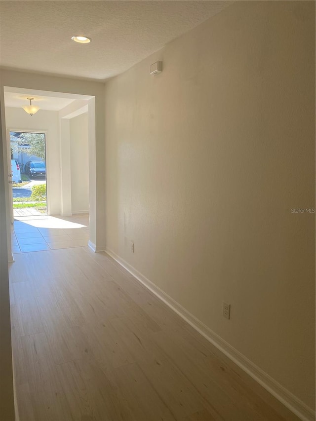 spare room with recessed lighting, wood finished floors, and baseboards