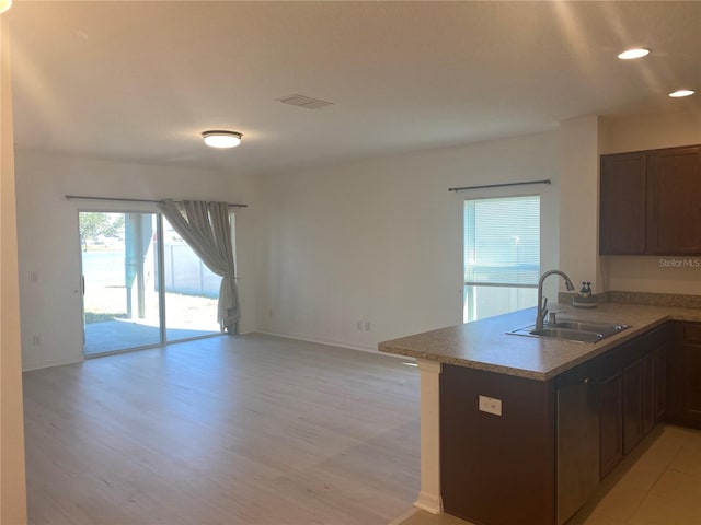 kitchen featuring visible vents, a peninsula, recessed lighting, a sink, and open floor plan