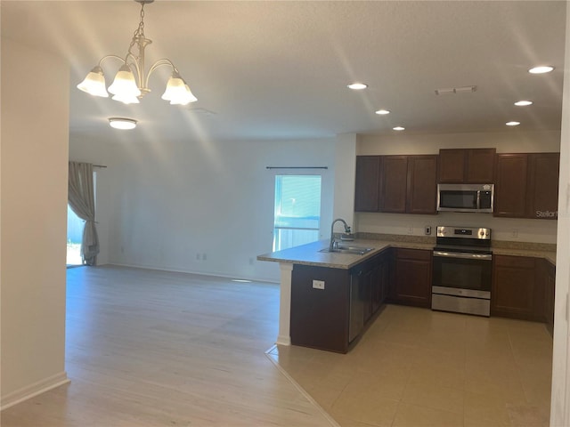 kitchen featuring a sink, stainless steel appliances, a peninsula, and a wealth of natural light