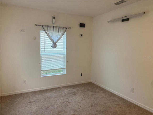 unfurnished room with visible vents, carpet floors, and baseboards