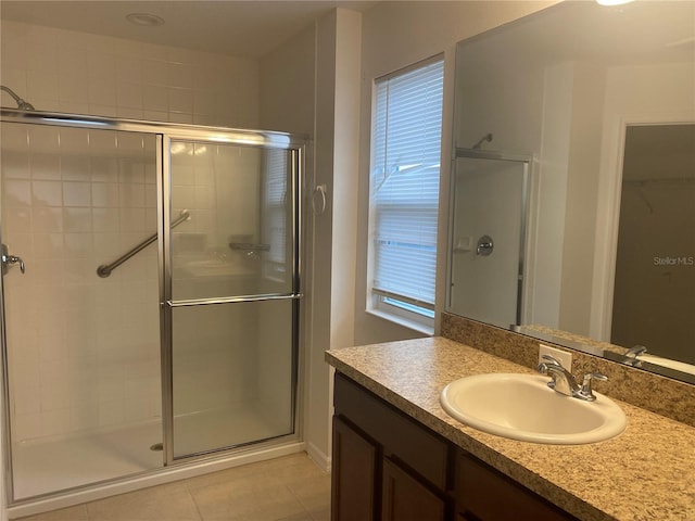 bathroom with tile patterned flooring, a shower stall, and vanity