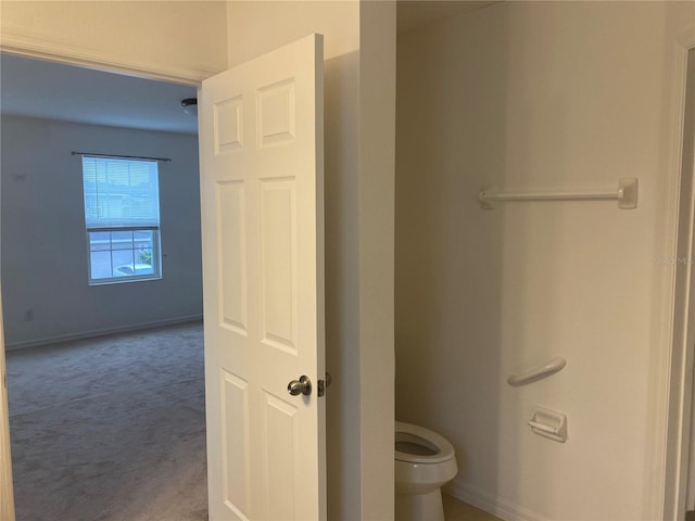 bathroom featuring toilet and baseboards