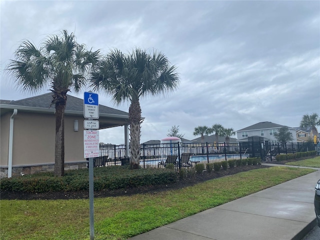 view of community featuring a pool and fence