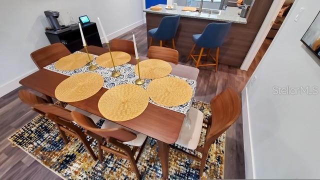 dining area with baseboards and wood finished floors