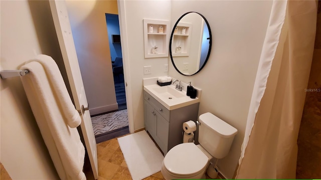 full bath with toilet, baseboards, and vanity