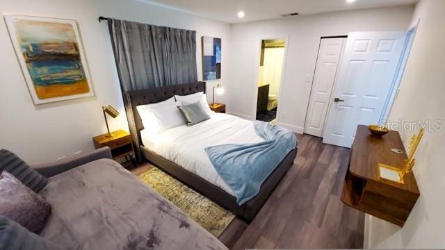 bedroom with recessed lighting, ensuite bathroom, and wood finished floors