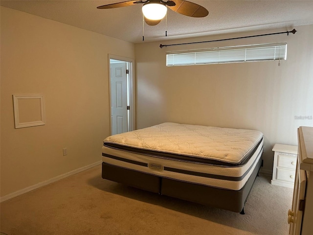 bedroom featuring light colored carpet, ceiling fan, and baseboards