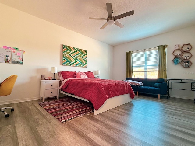 bedroom featuring baseboards, a textured ceiling, a ceiling fan, and wood finished floors