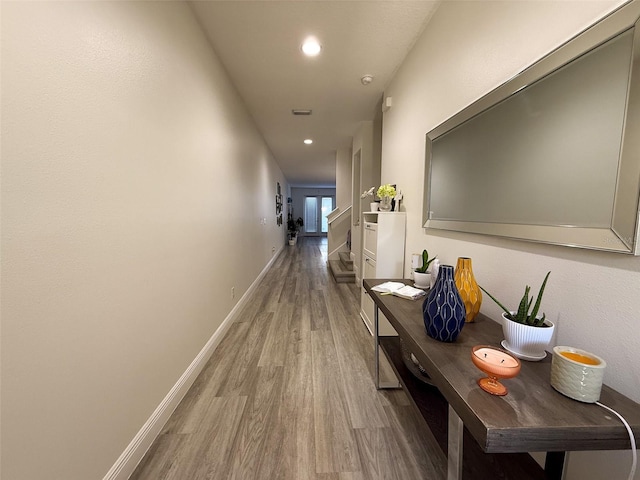 hall featuring recessed lighting, wood finished floors, and baseboards