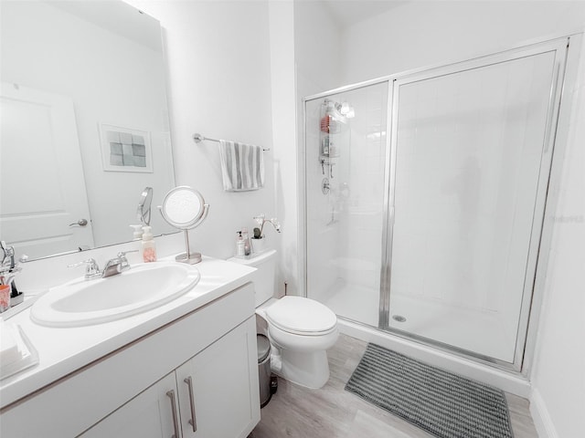 bathroom with vanity, a shower stall, and toilet