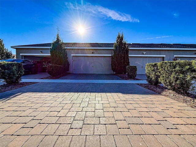 view of front of home featuring stucco siding, decorative driveway, and an attached garage