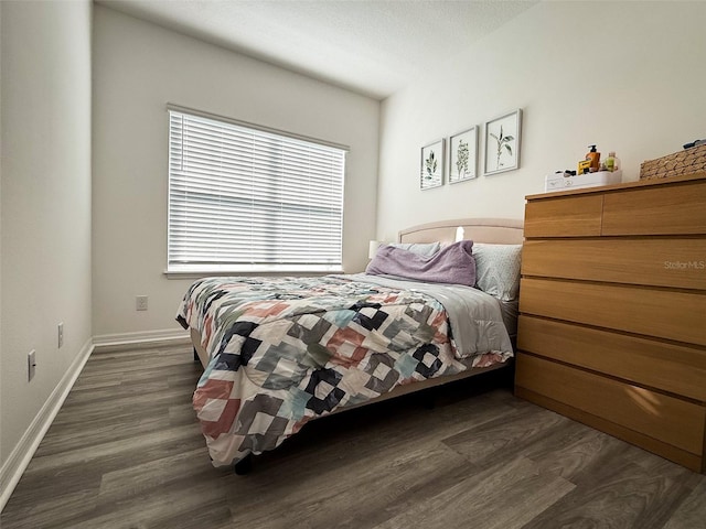 bedroom with dark wood finished floors and baseboards