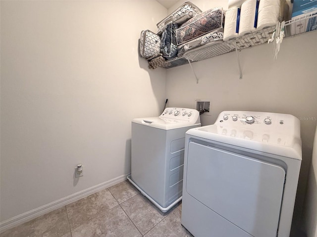 laundry room featuring washer and dryer, laundry area, light tile patterned flooring, and baseboards