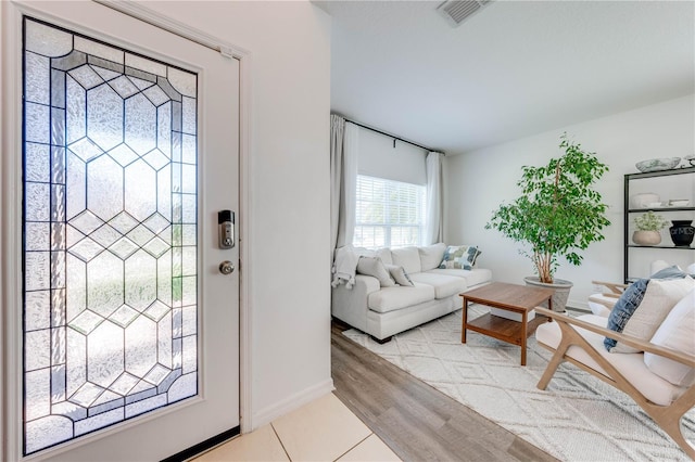 entryway with visible vents, baseboards, and wood finished floors