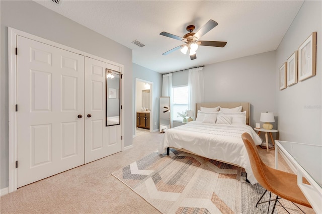 bedroom with visible vents, baseboards, ceiling fan, light colored carpet, and ensuite bathroom