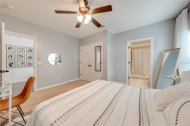 bedroom featuring visible vents, connected bathroom, baseboards, light colored carpet, and a closet