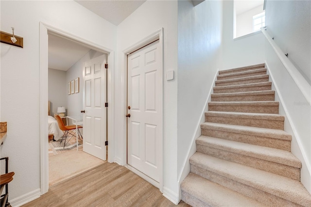 staircase with baseboards and wood finished floors