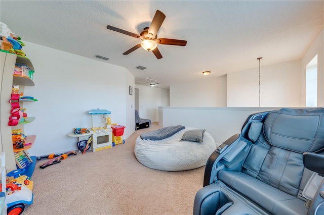 rec room featuring visible vents, a textured ceiling, a ceiling fan, and carpet