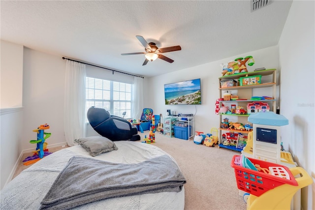 bedroom featuring a ceiling fan, baseboards, visible vents, carpet floors, and a textured ceiling