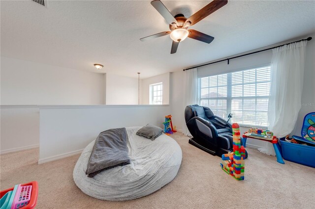 recreation room with carpet flooring, a textured ceiling, and baseboards