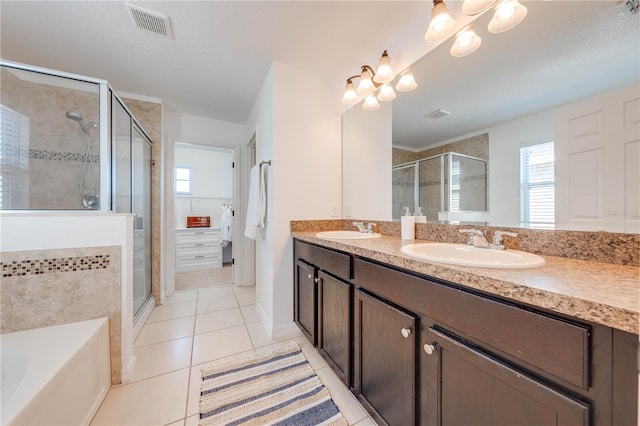 full bath featuring visible vents, a stall shower, a sink, tile patterned flooring, and a walk in closet