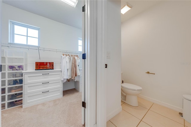 bathroom with tile patterned floors, baseboards, and toilet