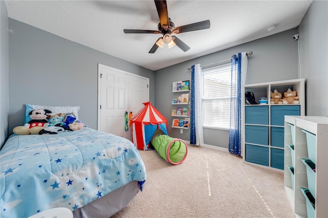 bedroom featuring baseboards, carpet floors, a textured ceiling, and a ceiling fan