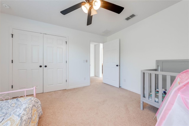 bedroom with a closet, visible vents, carpet flooring, and baseboards