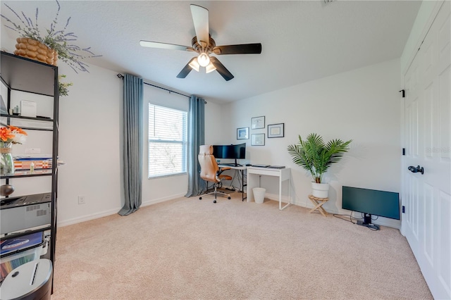 carpeted office with a ceiling fan and baseboards