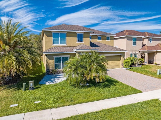 view of front facade featuring stucco siding, decorative driveway, a garage, and a front yard