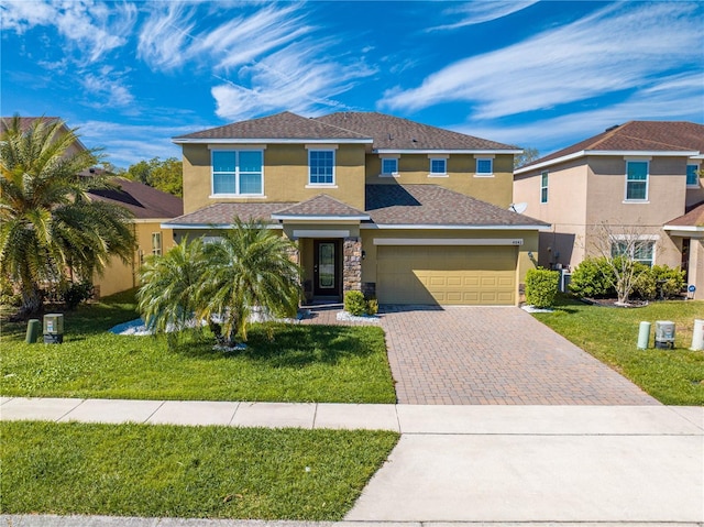 view of front of house featuring stucco siding, decorative driveway, and a front lawn