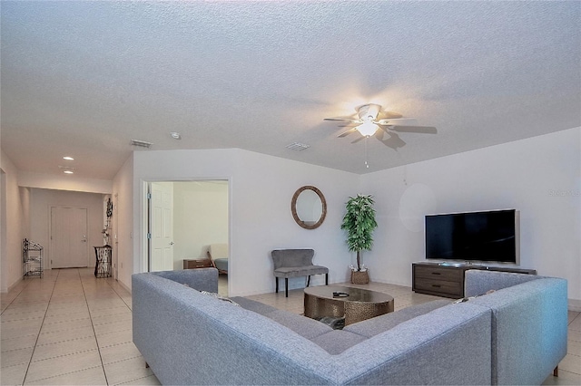 living room with light tile patterned floors, visible vents, a textured ceiling, and a ceiling fan