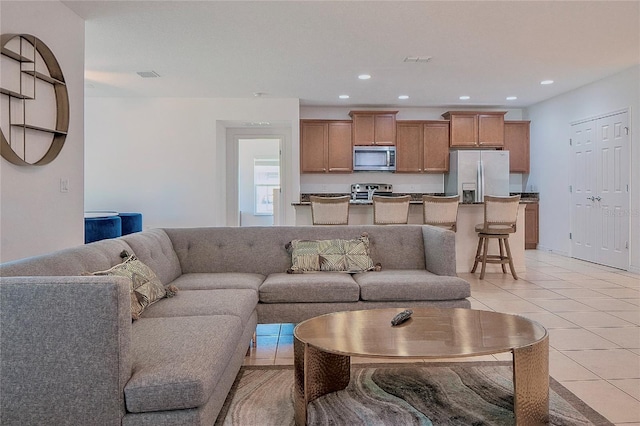 living room with light tile patterned floors, visible vents, and recessed lighting