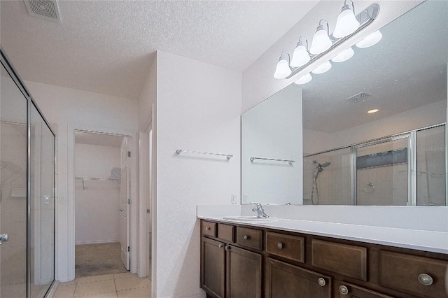 full bathroom featuring visible vents, a stall shower, and vanity