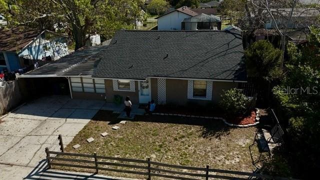 view of front facade with concrete driveway and fence