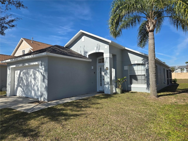 exterior space with a lawn, a garage, and stucco siding