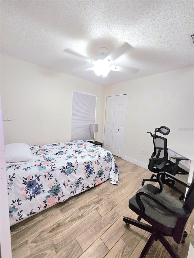 bedroom featuring a closet, light wood-style floors, and a textured ceiling