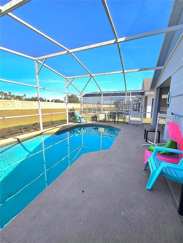 pool featuring glass enclosure and a patio