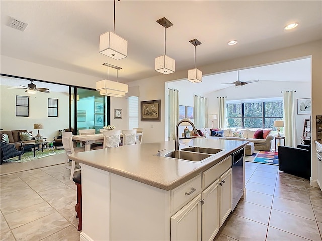 kitchen featuring open floor plan, dishwasher, light countertops, and a sink
